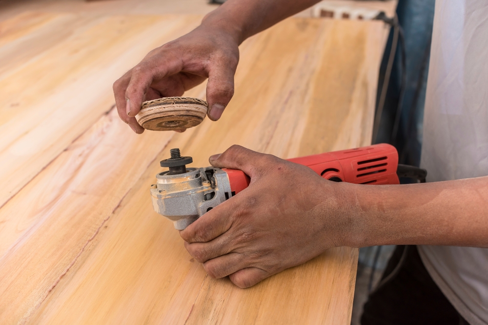 a worker attaching a sanding disc to a grinder